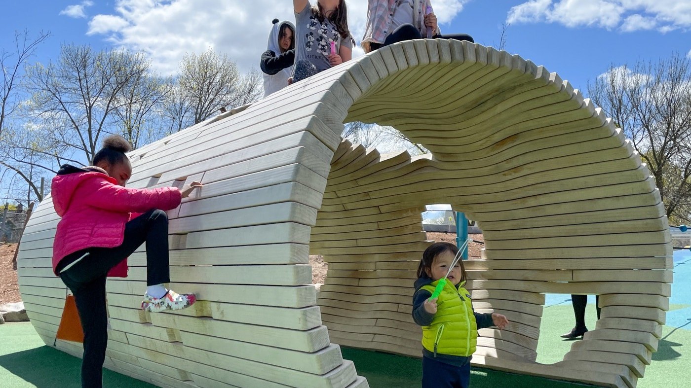 Pipe Dreams, a tunnel-shaped climbing structure of curved wooden planks, built at Danehy Park